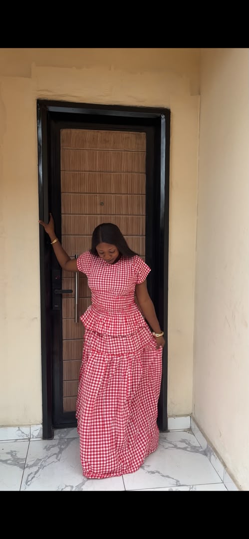 Woman wearing red and white gingham check tiered maxi dress with flutter sleeves and peplum waist