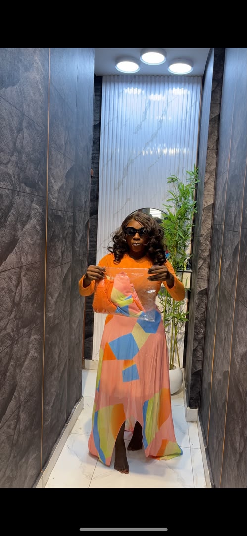 Woman wearing orange long-sleeve maxi dress with multicolour geometric abstract print