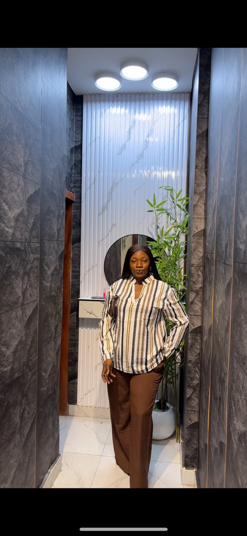 Woman wearing white and brown striped long-sleeve shirt with chocolate brown wide-leg trousers