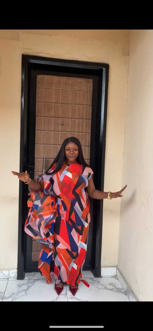Woman wearing bold geometric abstract print maxi dress in red, orange, navy and blush